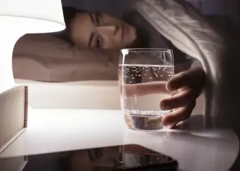 E lini një gotë ujë pranë shtratit gjatë natës? Ja pse nuk është aq e padëmshme sa mendoni!