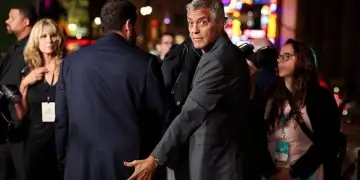 Momente gazmore në Hollywood: George Clooney vendos me shaka dorën mbi të pasmet e Adam Sandler